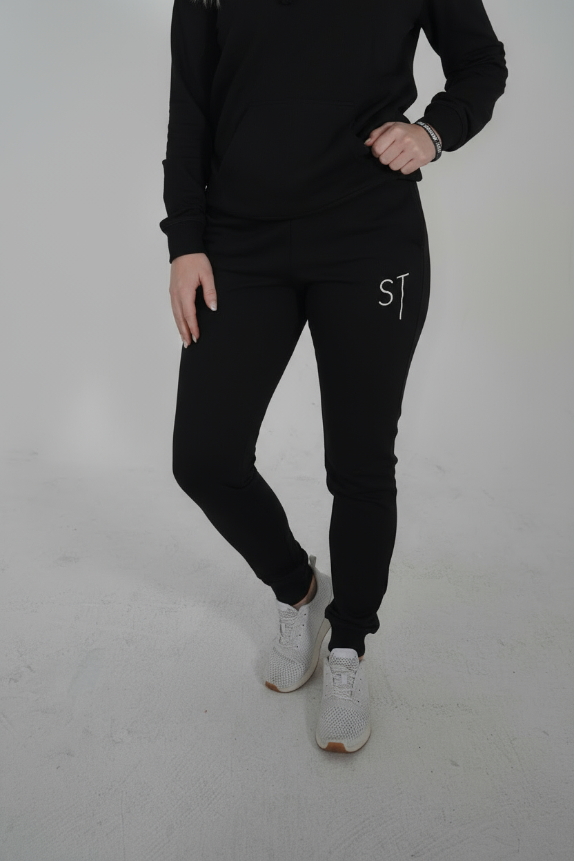 Black joggers fosomeone tall, with white letters spelling 'ST'.