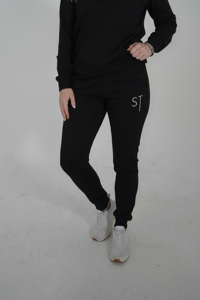 Black joggers fosomeone tall, with white letters spelling 'ST'.
