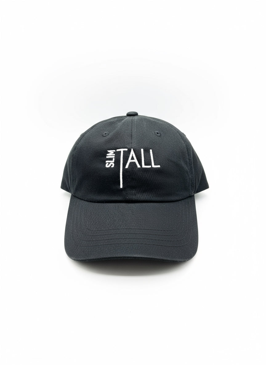 A black and white slim-fit dad hat with the text 'It's all about the slim TALL' printed on the front.