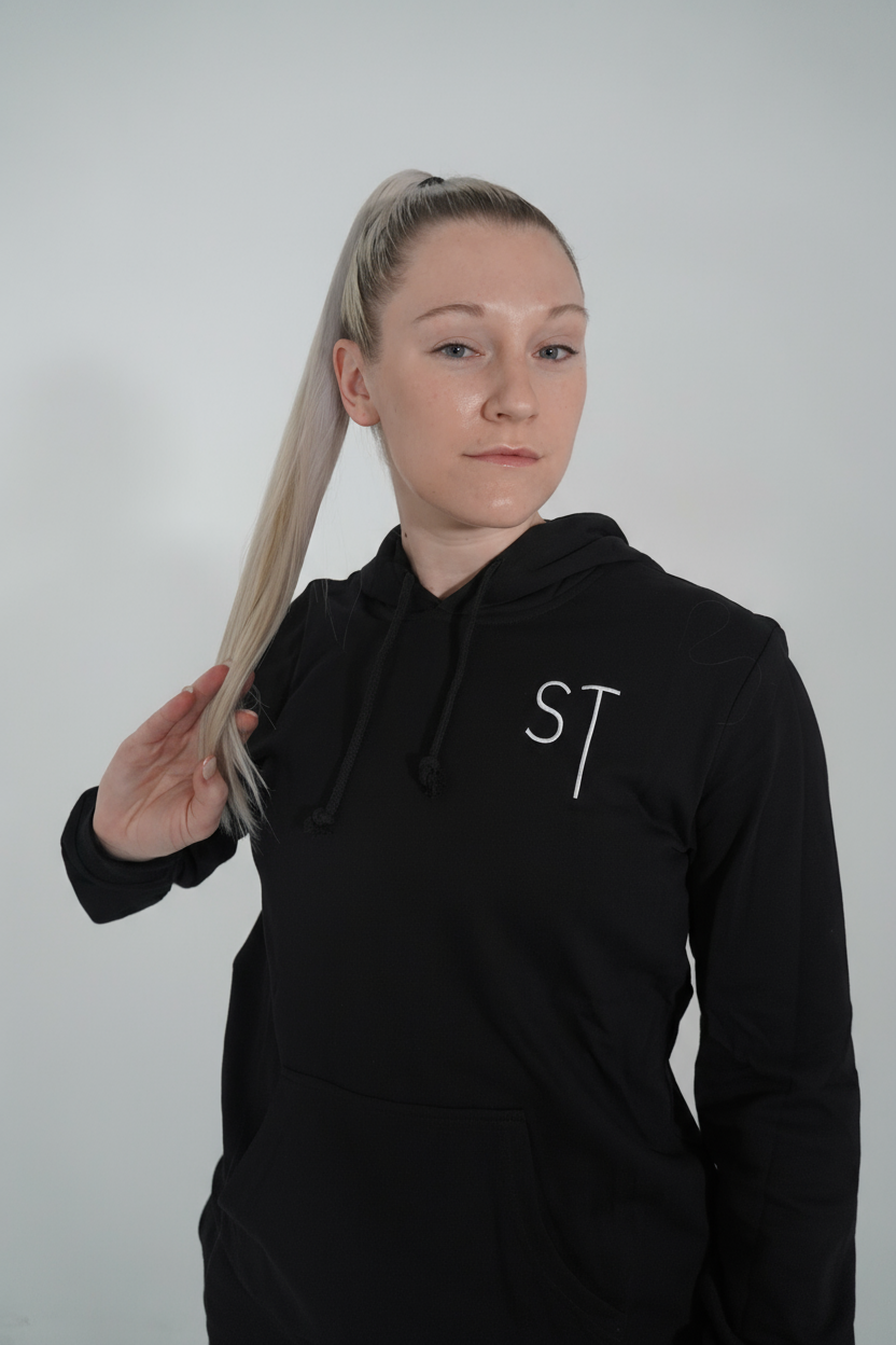 Person wearing a black hoodie with a logo on a plain background