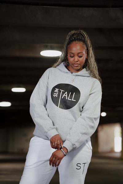 SlimTall Signature Hoodie in grey with the black circle logo, worn with the white tracksuit joggers